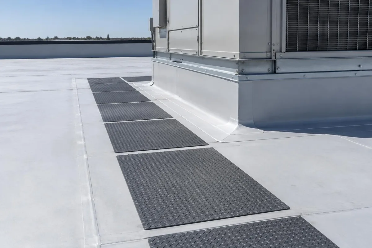 Close view of a rooftop equipment curb and clear access path on a low-slope roof